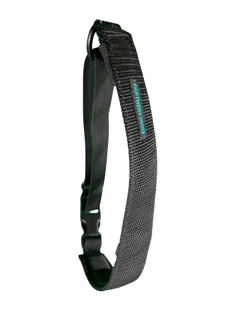 A black woven Partners Dogs branded dog collar with a D-ring and buckle, shown against a white background, representing training gear used correctly rather than as a punishment device.