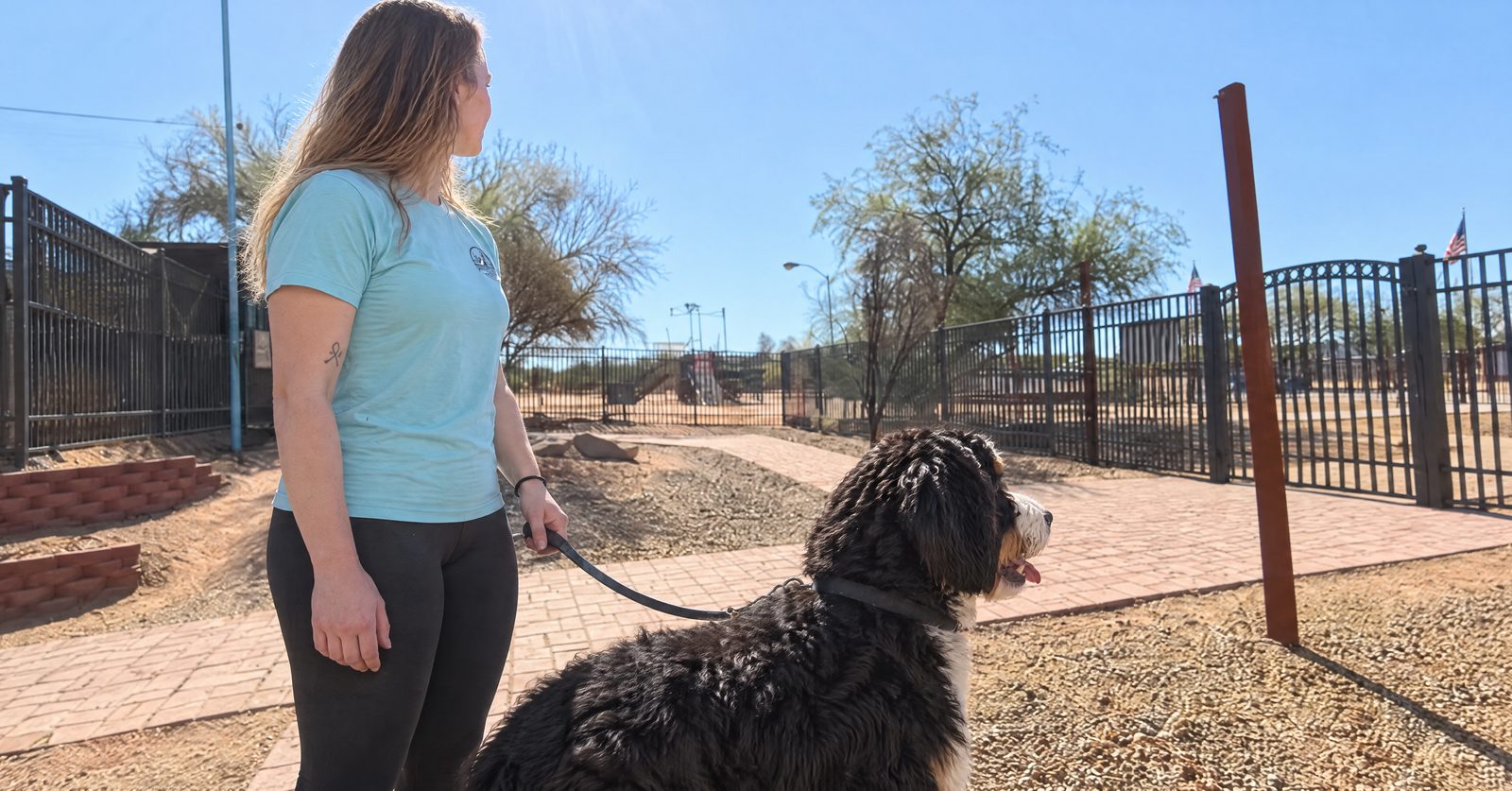 Partners trainer Rachel Woods works with a Bernedoodle that alert barks at the Cave Creek campus entrance