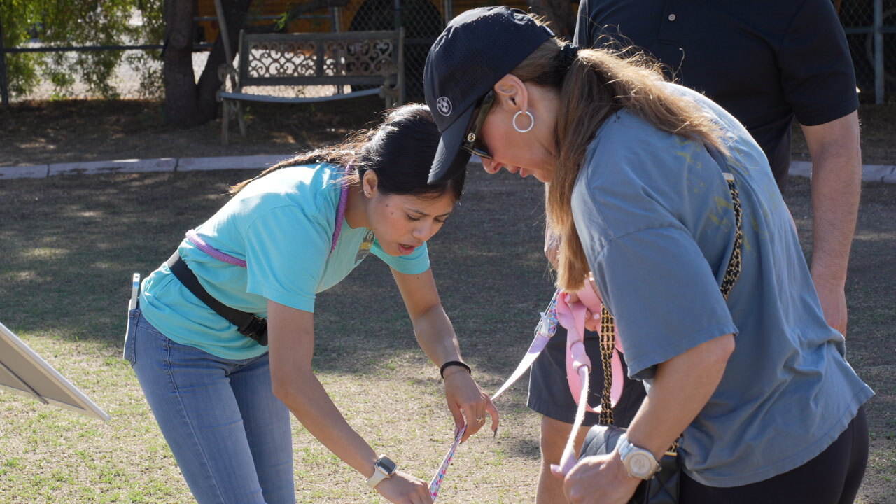 A Partners Dogs trainer coaching a client through a supervised training session with her dog